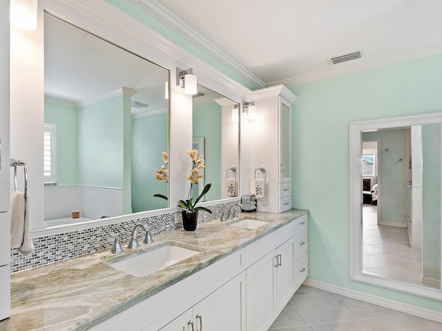 bathroom with tile patterned flooring, vanity, crown molding, and tasteful backsplash