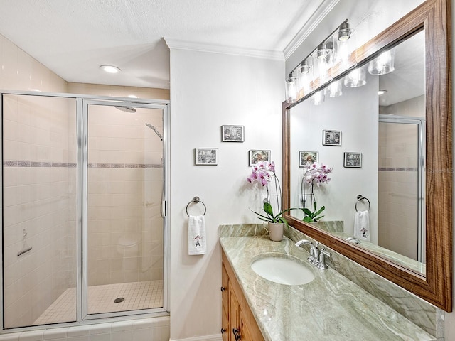 bathroom featuring walk in shower, vanity, crown molding, and a textured ceiling