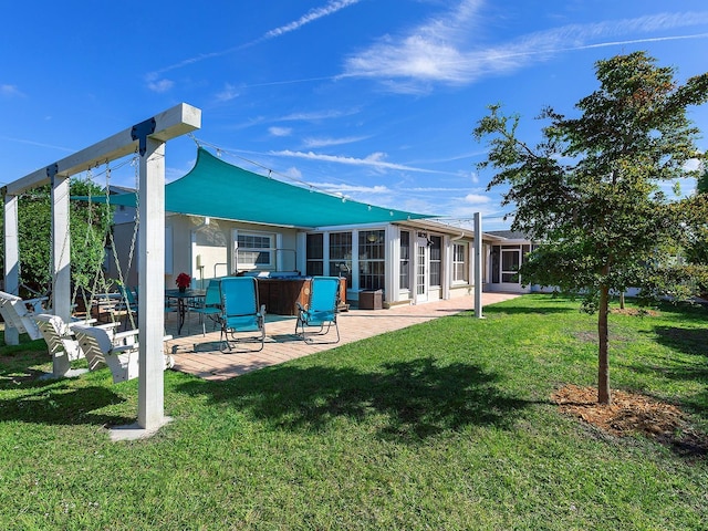 rear view of property featuring a sunroom, a yard, and a patio area