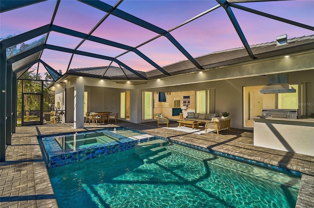 pool at dusk with area for grilling, an in ground hot tub, a lanai, an outdoor living space, and a patio area