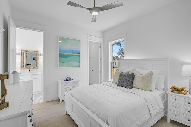 bedroom with ceiling fan, ensuite bathroom, and light hardwood / wood-style floors