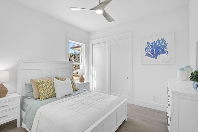 bedroom with ceiling fan, a closet, and light wood-type flooring