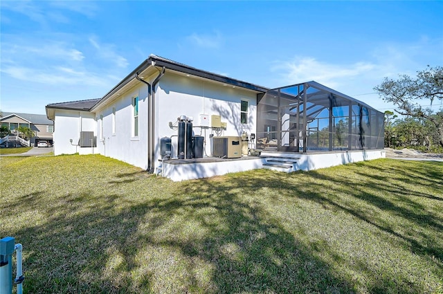 back of property featuring central AC, a patio, a lanai, and a lawn