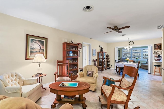 living room with ceiling fan with notable chandelier and light tile patterned floors