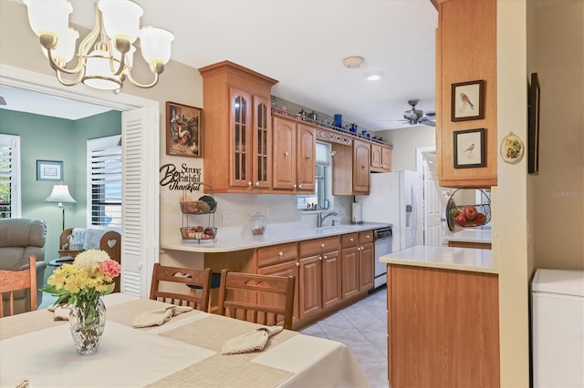 kitchen featuring sink, dishwasher, backsplash, hanging light fixtures, and light tile patterned flooring