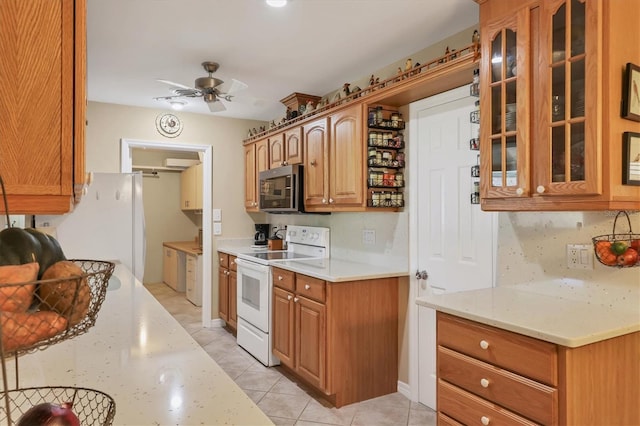 kitchen with ceiling fan, backsplash, light stone countertops, light tile patterned flooring, and white electric stove