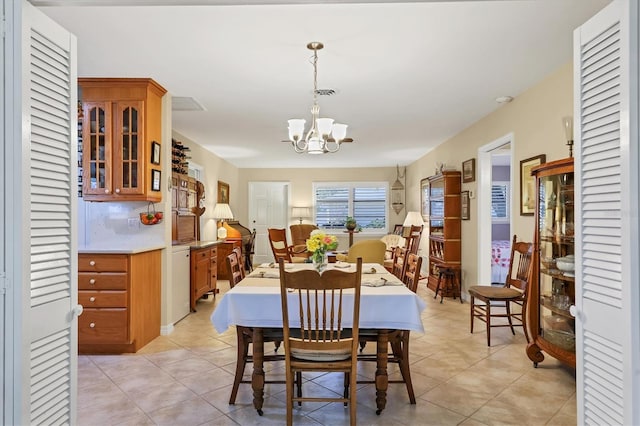 dining room featuring light tile patterned flooring and a chandelier