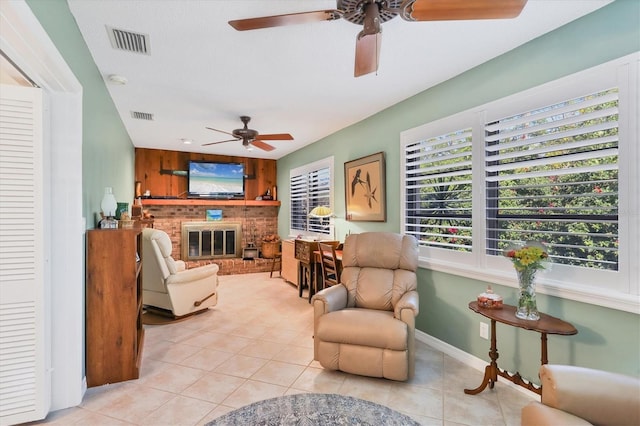 tiled living room with a brick fireplace and ceiling fan