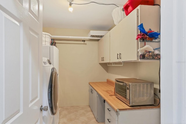 washroom featuring cabinets, light tile patterned flooring, and washer and dryer