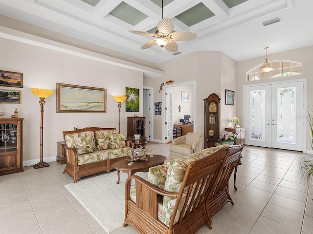 tiled living room with coffered ceiling, beam ceiling, french doors, and ceiling fan