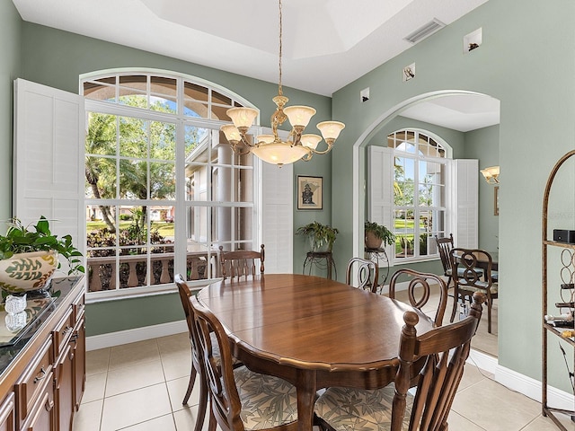 tiled dining room with a notable chandelier