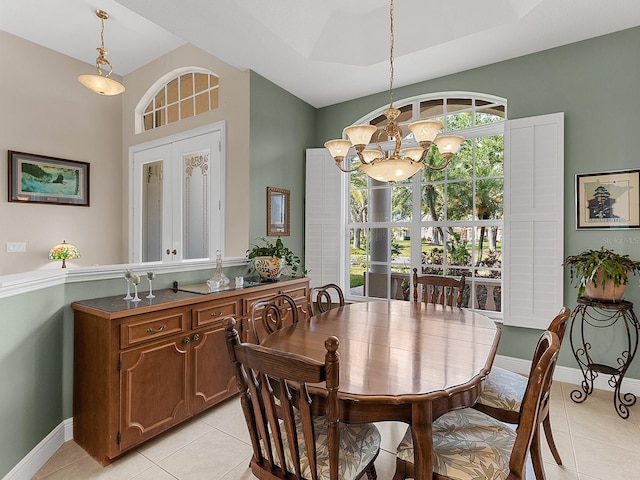 tiled dining room with a chandelier