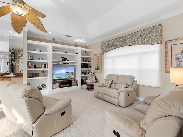 carpeted living room with crown molding, ceiling fan, and a tray ceiling