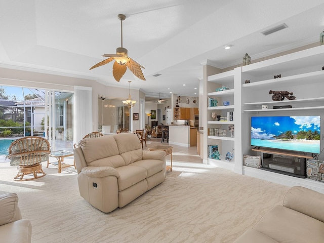 living room featuring ornamental molding, a tray ceiling, and ceiling fan with notable chandelier