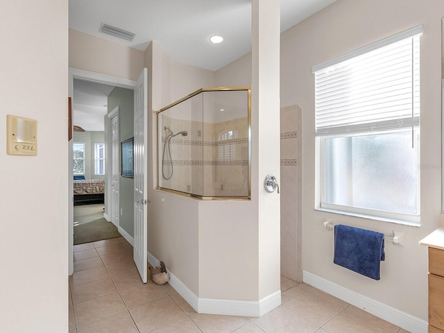 bathroom featuring tile patterned flooring, vanity, and tiled shower