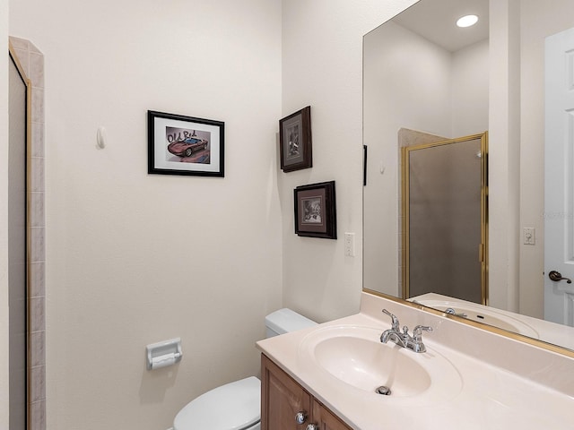 bathroom featuring an enclosed shower, vanity, and toilet