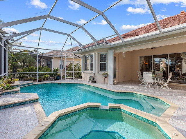 view of swimming pool featuring an in ground hot tub, a patio, and glass enclosure