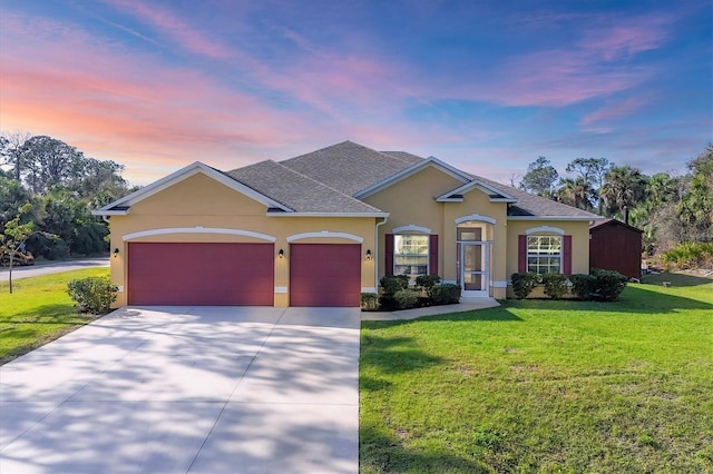 view of front of house featuring stucco siding, a shingled roof, a front yard, a garage, and driveway