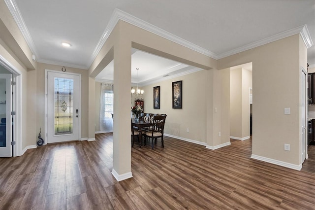 foyer featuring dark wood-style floors, baseboards, ornamental molding, and an inviting chandelier