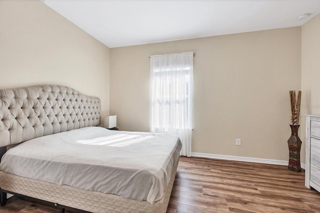 bedroom featuring wood finished floors and baseboards