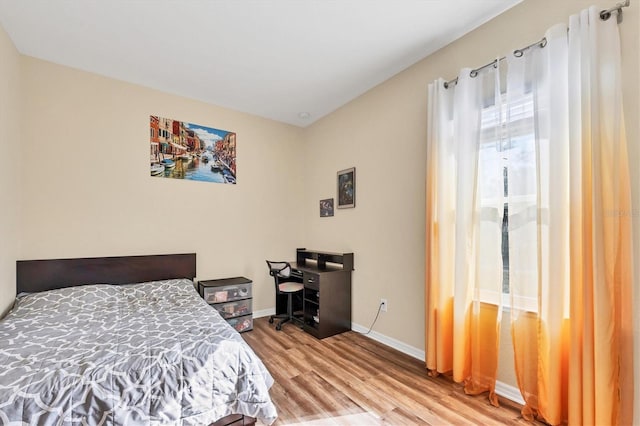 bedroom with baseboards and wood finished floors