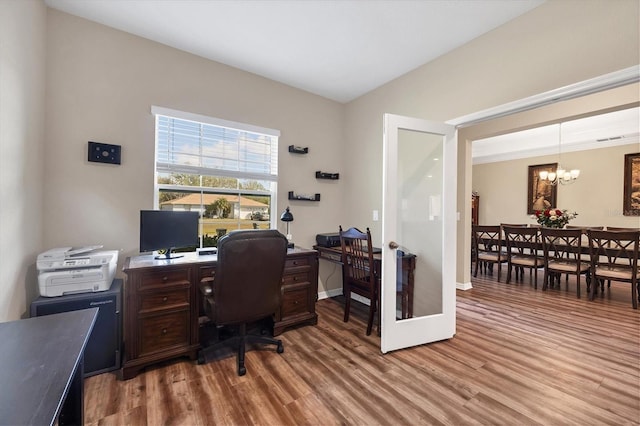 office featuring a chandelier, visible vents, baseboards, and wood finished floors