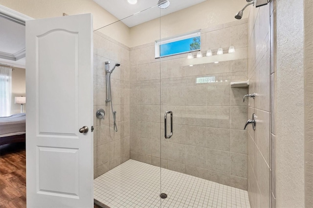 bathroom with ensuite bathroom, a stall shower, and wood finished floors