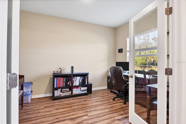 office area with baseboards and wood finished floors