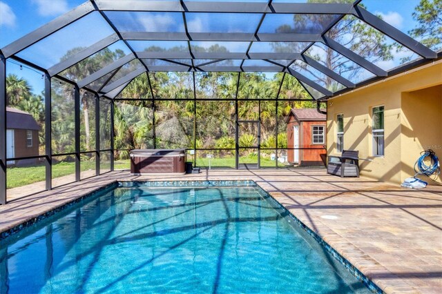 outdoor pool featuring a hot tub, a shed, a patio, and an outbuilding