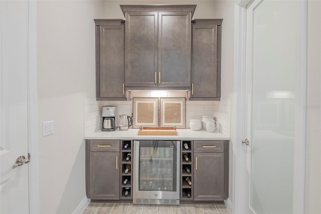 bar with wine cooler and dark brown cabinetry