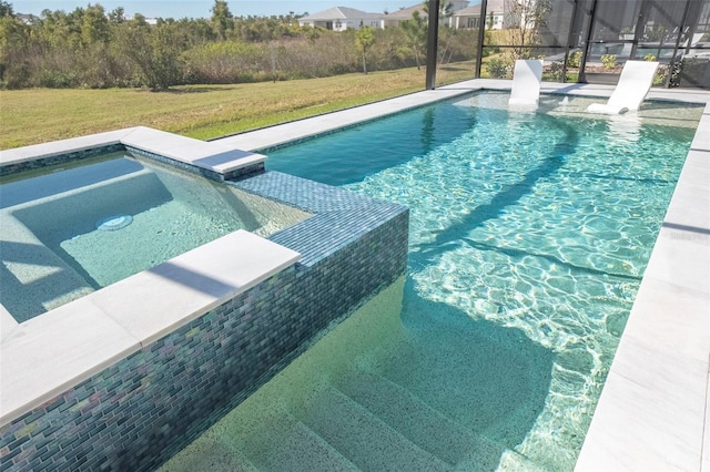 view of pool with an in ground hot tub and a lawn