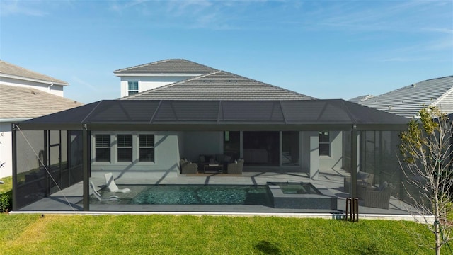 back of house featuring a swimming pool with hot tub, a patio, a yard, and glass enclosure