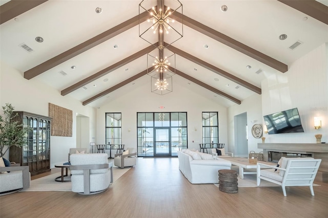 living room featuring a notable chandelier, high vaulted ceiling, and light hardwood / wood-style floors