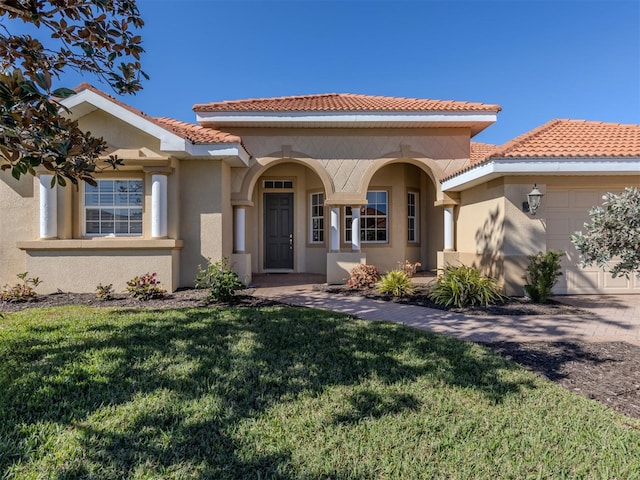 mediterranean / spanish-style house featuring a garage and a front yard