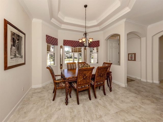 dining space featuring crown molding, a raised ceiling, and a chandelier