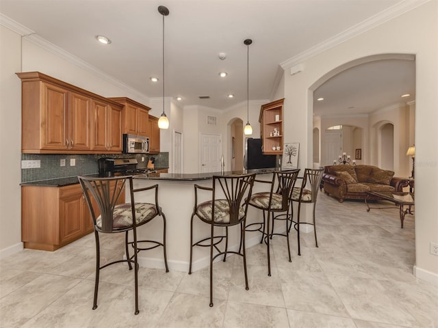 kitchen featuring decorative light fixtures, tasteful backsplash, kitchen peninsula, stainless steel appliances, and crown molding