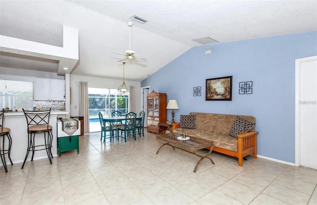 living room with ceiling fan, lofted ceiling, and light tile patterned floors