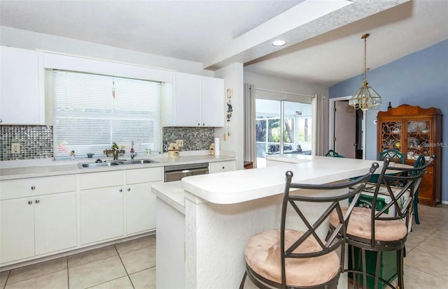 kitchen with hanging light fixtures, a breakfast bar area, a center island, and white cabinets