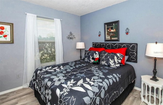 bedroom featuring wood-type flooring and a textured ceiling