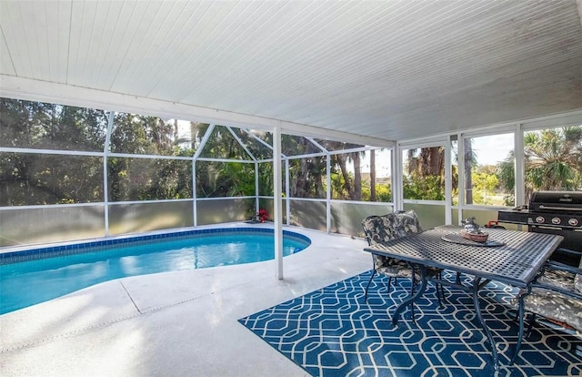 view of swimming pool with a patio, area for grilling, and glass enclosure