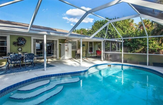 view of pool with a patio and glass enclosure