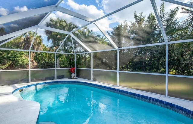 view of pool with glass enclosure