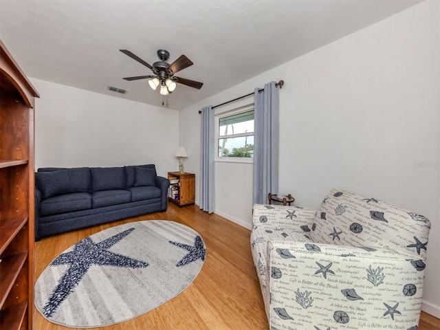 living room featuring ceiling fan and hardwood / wood-style floors