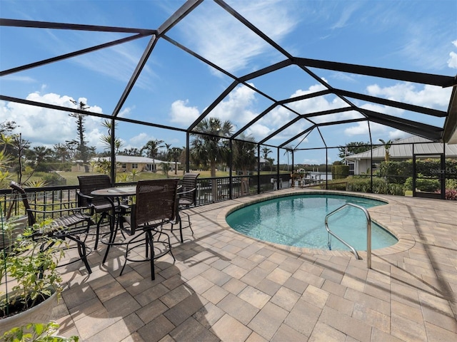 view of pool with a patio area and glass enclosure