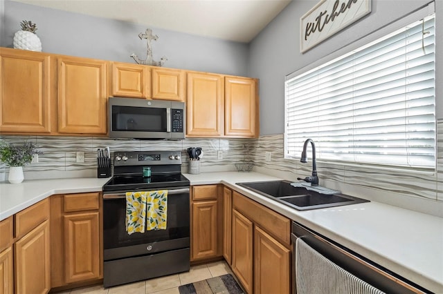 kitchen with sink, decorative backsplash, stainless steel appliances, and light tile patterned floors