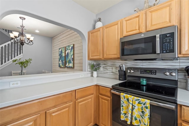 kitchen with light brown cabinetry, hanging light fixtures, a notable chandelier, black range with electric stovetop, and decorative backsplash