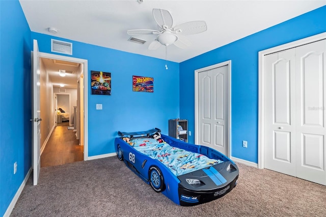 carpeted bedroom with multiple closets and ceiling fan