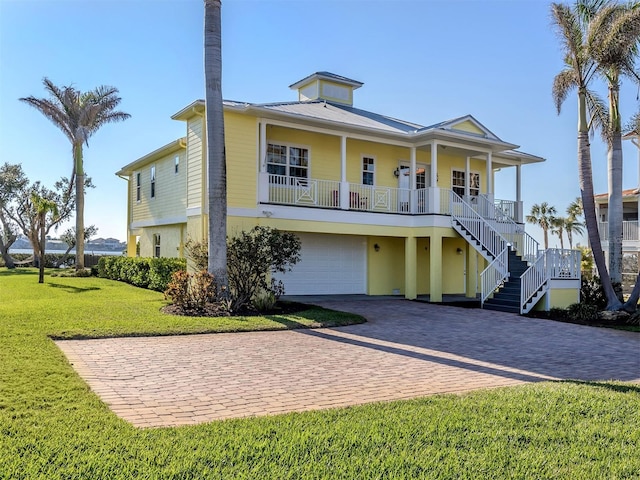 view of front of home featuring a garage, a front yard, and a porch