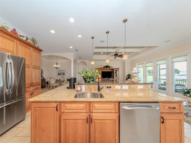 kitchen featuring sink, light stone counters, light tile patterned floors, stainless steel appliances, and a kitchen island with sink