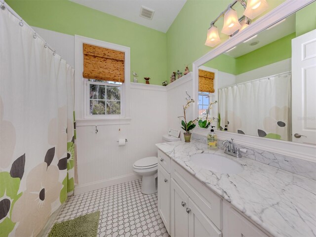 bathroom with vanity, a healthy amount of sunlight, and toilet